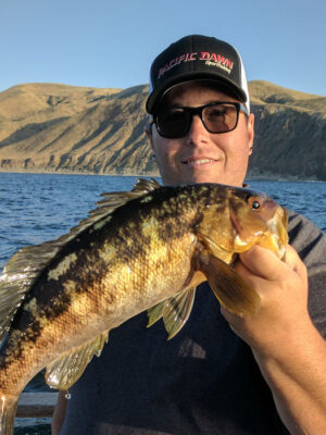 Luke Fitzpatrick hold a big fish he caught in the ocean